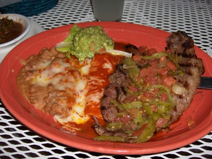 Tampiqueña steak with a red enchilada and guacamole