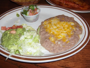 Guacamole, beans, and pico de gallo are served with fajitas