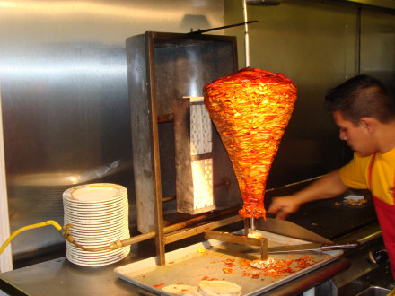 Cooking tacos al pastor on a rotisserie